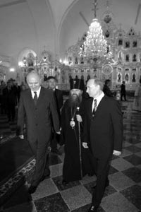 Russian President Vladimir Putin and President of the Republic of Mordovia Nikolai Merkushkin are followed by a Russian orthodox priest as they visit the St. Warrior Fyodor Ushakov’s Cathedral in Saransk August 10, 2006